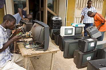 Workers repairing electronics at a shop in Accra, Ghana. The computers are shipped here from Europe and the USA and some are reused but majority are dumped in Ghana.