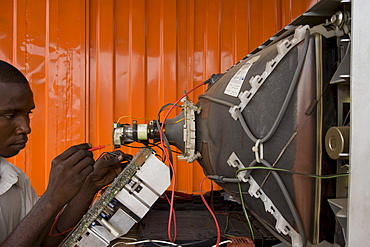 Workers repairing electronics at a shop in Accra, Ghana. The computers are shipped here from Europe and the USA and some are reused but majority are dumped in Ghana.