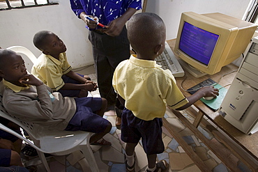 Yinka Ogunsuyi teaches a computer class to 9-11 year olds from the Regency School in Lagos, Nigeria. He gets the computers from a contact in the USA and also buys some in Nigeria. The computer is a Pentium 3 Dell from the USA. Also at the school 2-3 year olds watch the movie "Happy Feat" on a Pentium 4 computer.