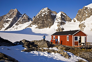 A group of adventure skiers relax at a mountain hut near the Karale Glacier on Ammassalik Island, Greenland.