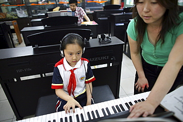 Chinese seven-year-old Shen Siyue at her weekly piano lesson at school in Beijing, China.