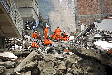 A rescue team look for survivors in the rubble of Beichuan Town, which was severely damaged by a powerful 7.9 earthquake. The Chinese government raised the death toll to 21,500 but has said fatalities could rise above 50,000. Tens of thousands could still be buried in collapsed buildings in Sichuan province, where the quake was centered.