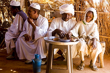 Camel traders and herders sit in a tea hut in a camel market in El Obeid, Sudan