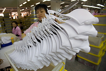 Chinese women pack bras for export to the United States in the shipping area of the Top Form factory in Longnan, China