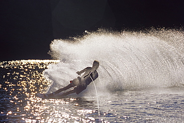 Male water skier backlit by the sun.