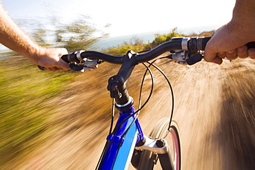 Point of view of a the handlebars of a mountain biker in Malibu, California. (motion blur)