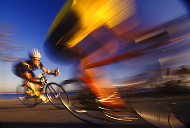 Two road cyclists race by on a turn on the Seattle waterfront in Washington.