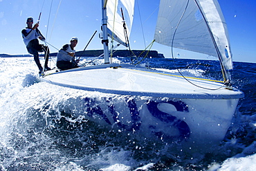 Two male athletes sail an Olympic class racing boat in Sydney Harbor, Australia.