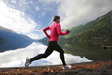 A female jogging along the Lake Crescent shore.