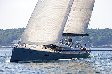 A crew races a modern ocean-going sailing yacht.