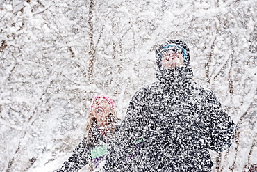 A young couple enjoys the falling snow in Milcreek Canyon, Salt Lake City, Utah.