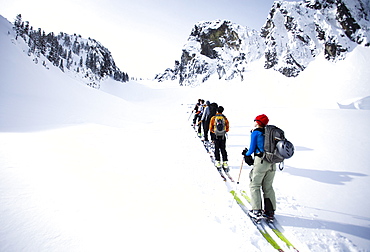 A group of skiers in the backcountry on a clear day.