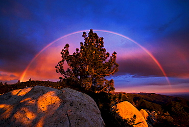 A rainbow is formed during a passing storm at sunset from White Mountain, CA.