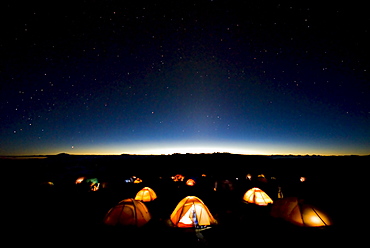 Tents illuminate the night as stars fill the sky on mMt. Kilimanjaro.