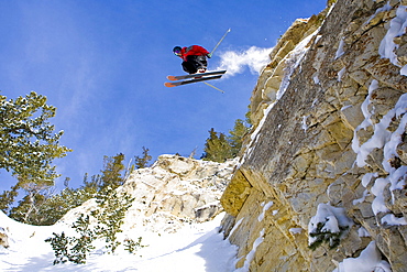 A skier catches some air off a large cliff at Snowbird, Utah