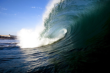 A large wave breaks close to shore.