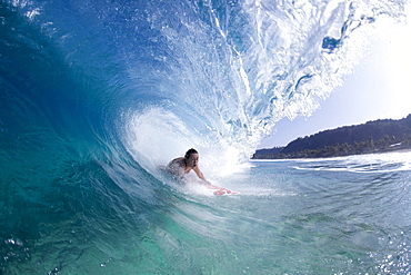 A water view of a surfer girl in the tube, in Hawaii.