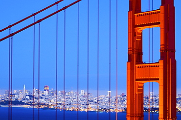 A detail of the Golden Gate Bridge at dusk with San Francisco in the background, California.