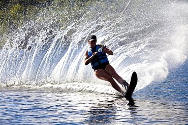 A female water skier rips a turn causing a huge water spray while skiing on Cobbosseecontee Lake near Monmouth, Maine.