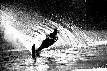 A female water skier rips a turn causing a huge water spray while skiing on Cobbosseecontee Lake near Monmouth, Maine.