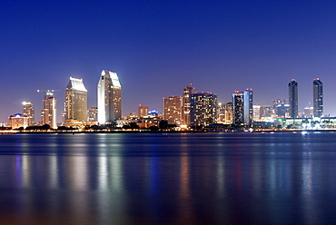 The San Diego skyline is illuminated at dusk as seen from Coronado Island, CA.