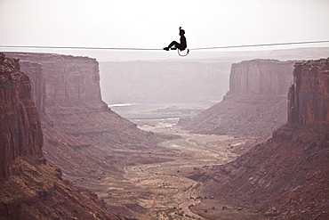 Andy Lewis working on a world record highline, three hundred and forty feet long, at the Fruit Bowl in Moab, Utah, USA.