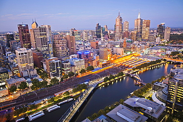 Looking across the Yarra River the lights come on in the central business district of Melbourne on the evening of 27th January 2012, Victoria, Australia.