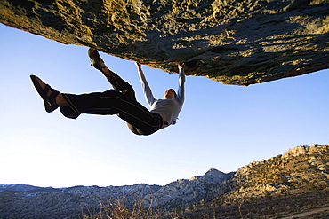 Woman bouldering on an overhang