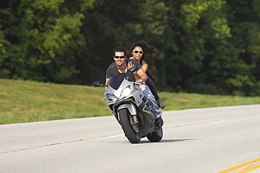 Young couple ridding a sport bike on a country road in Kansas