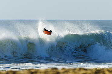 Bodyboarder does a massive air reverse, backlite by the sunset, at Nazare Special Edition, held in Nazare, Portugal.