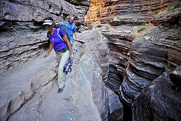 Hikers walk along Deer Creek Narrows in the Grand Canyon outside of Fredonia, Arizona November 2011.  The 21.4-mile loop starts at the Bill Hall trailhead on the North Rim and descends 2000-feet in 2.5-miles through Coconino Sandstone to the level Esplanada then descends further into the lower canyon through a break in the 400-foot-tall Redwall to access Surprise Valley.  Hikers connect Thunder River and Tapeats Creek to a route along the Colorado River and climb out Deer Creek.