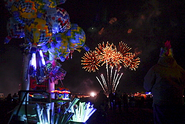 Fireworks light the night sky. The Albuquerque International Balloon Fiesta takes place in Albuquerque, New Mexico each year drawing in participants and spectators from across the globe. Highlights include an early morning dawn patrol, followed by mass ascencion of aircraft and an evening glow which all take place at the Balloon Fiesta Park throughout the week long event.