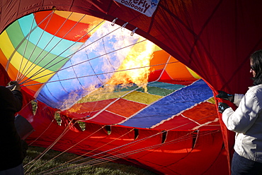 Crews work carefully, inflating their hot air balloons for launch. The Albuquerque International Balloon Fiesta takes place in Albuquerque, New Mexico each year drawing in participants and spectators from across the globe. Highlights include an early morning dawn patrol, followed by mass ascencion of aircraft and an evening glow which all take place at the Balloon Fiesta Park throughout the week long event.