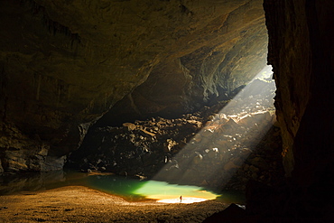 A caver stands in a sunbeam coming through an entrance to Hang En Cave in Phong Nha Ke Bang National Park, Vietnam. This natural phenomenon occurs only in the months of December and January.