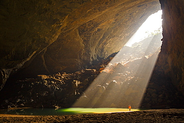 A caver stands in a sunbeam coming through an entrance to Hang En Cave in Phong Nha Ke Bang National Park, Vietnam. This natural phenomenon occurs only in the months of December and January.