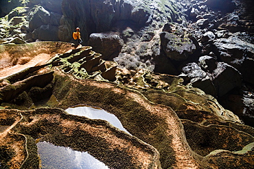 A cave explorer stands on rimstone formations in Hang Son Doong, Vietnam.