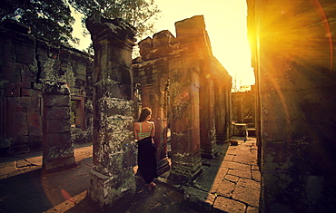 A beautiful woman in the ruins of an ancient temple Ta Prohm, the Tomb Raider Temple in Cambodia.