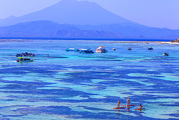 People travels by SUP surfboards at coastline of Nusa Lembongan and Nusa Ceningan islands, Indonesia.