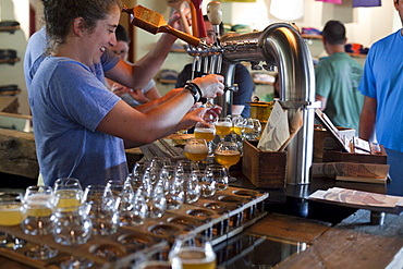 Bartender pours beers for tasting at Allagash Brewery