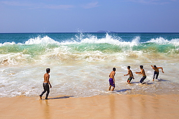 Young boys playing near the ocean.