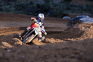 Motocross racer turns through a rutted corner while racing at Blackwood park.