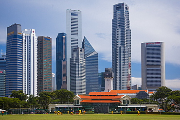 A cricket match goes on in front of the Singapore financial district skyline.