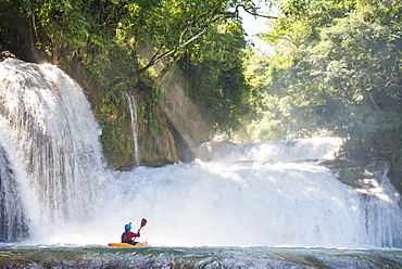 One man on his kayak below some waterfalls in Cascadas de Agua Azul, Chiapas, Mexico.