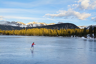 A girl ice skating on early season ice, Molas Lake, San Juan National Forest, Silverton, Colorado.