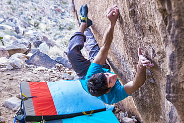 Male rock climber tries difficult boulder problem in Red Rock National Park, outside Las Vegas, Nevada