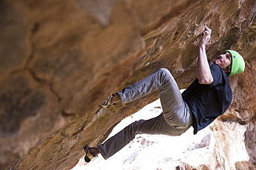 Professional male climber bouldering in Hueco Tanks, Texas during the Hueco Rock Rodeo