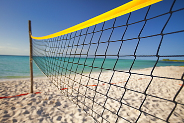 A beach volleyball net set up beside the ocean on Playa La Jaula beach, Cayo Coco, Cuba.