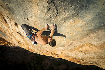 A man climbing 'La tentación de seguir,' a hard route full of monofinger in Sierra de Guara