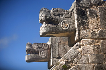 Two heads representing Kukulkan, the Feathered Serpent god, decorate a building in the Mayan city of Chichen Itza, Yucatan Peninsula, Mexico