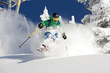 A man skiing powder on a beautiful sunny day in Utah.